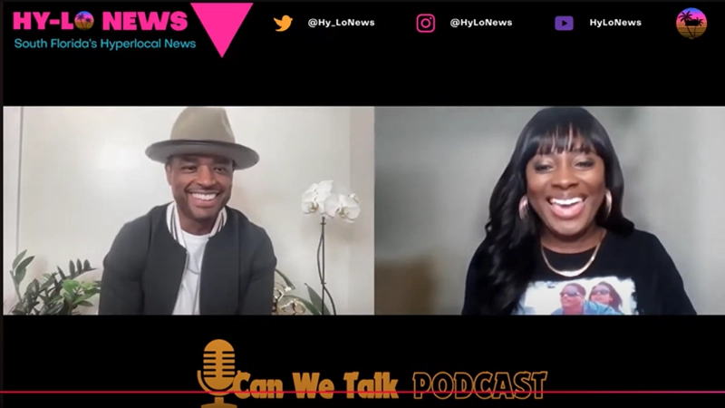 Black man with gray hat on a video screen with a Black woman wearing gold jewelry. Both are smiling and talking.