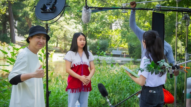 Four people filming with camera equipment outdoors