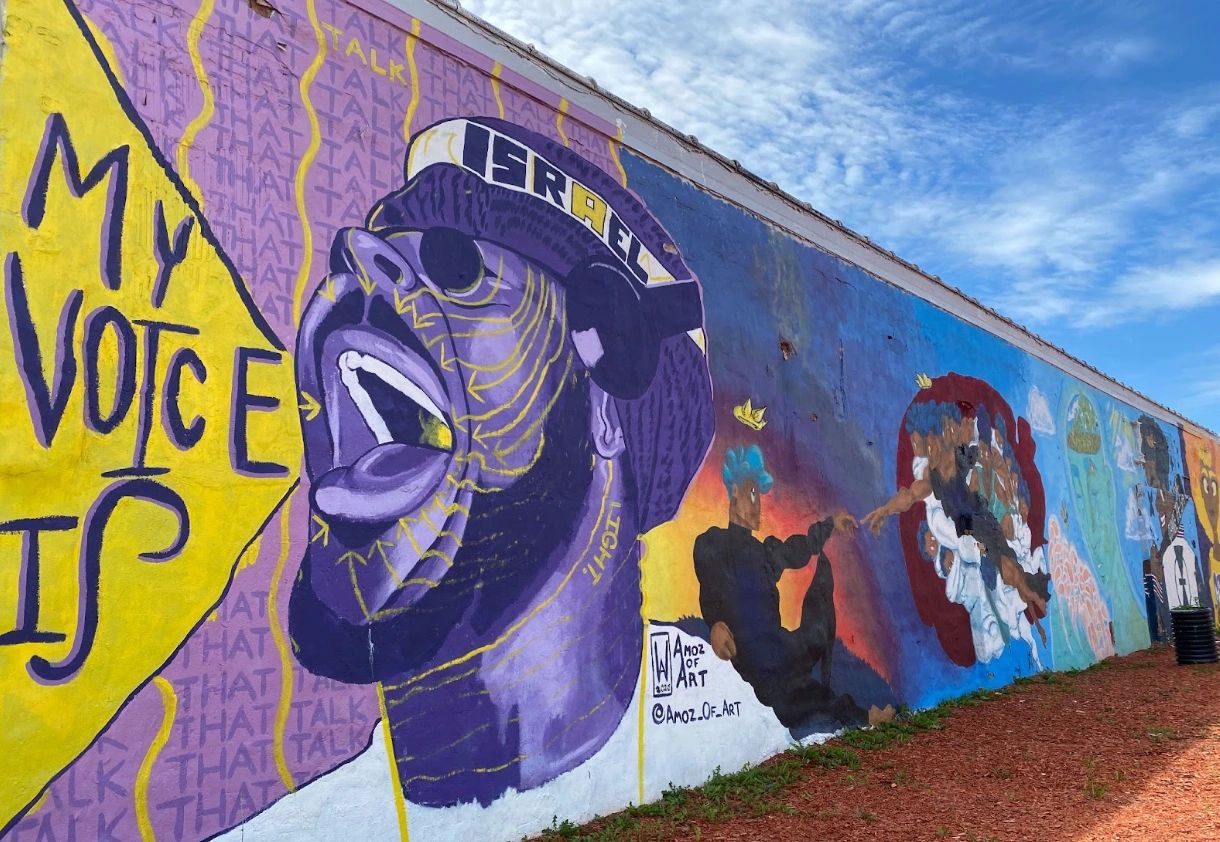 Colorful mural featuring expressive Black man saying "My Voice Is..."
