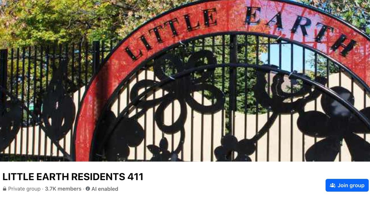 Photo of Little Earth front gate, which is black metal with the words Little Earth on the top arch with a red background.