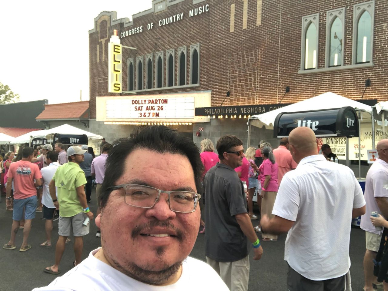 Indigenous man takes a selfie in front of a community event