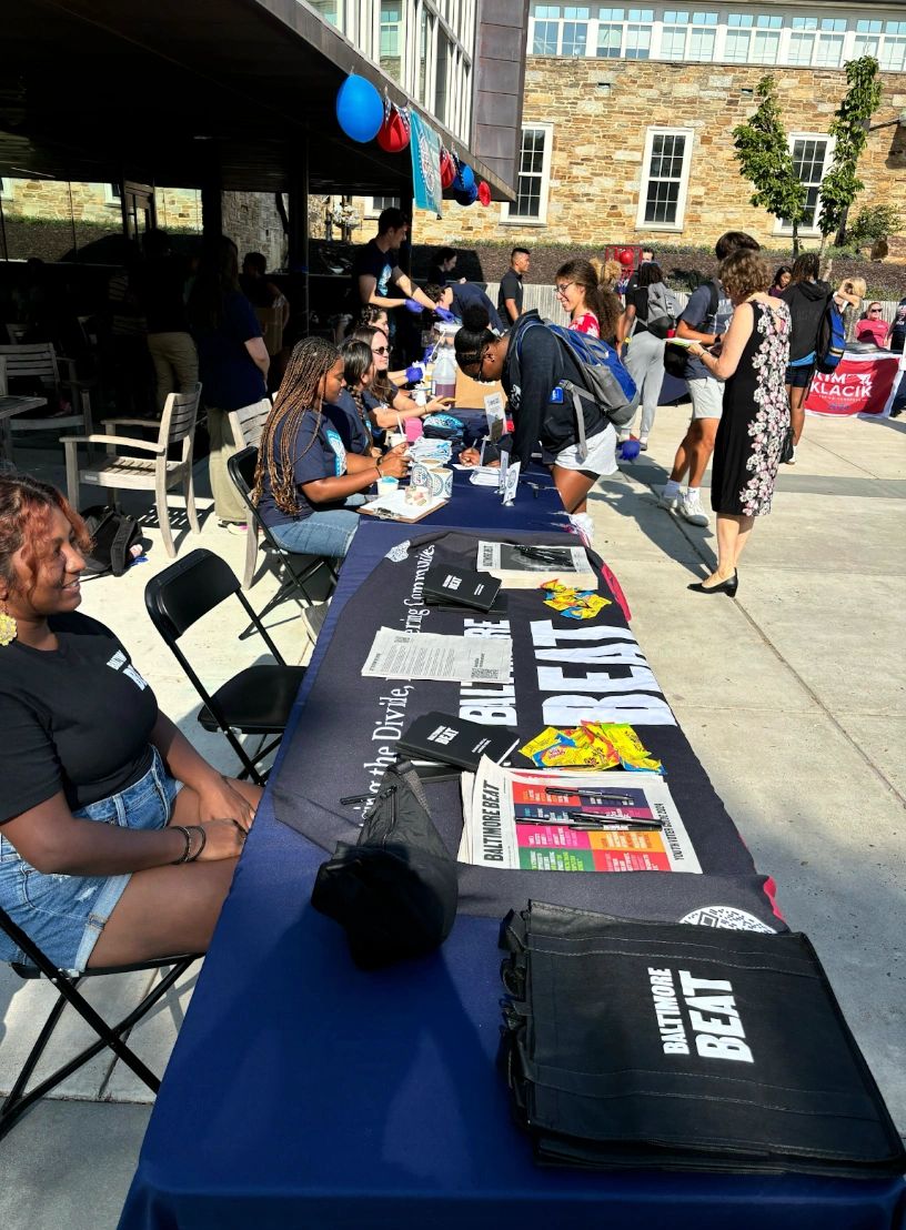 People at an outdoor community event with tables and information