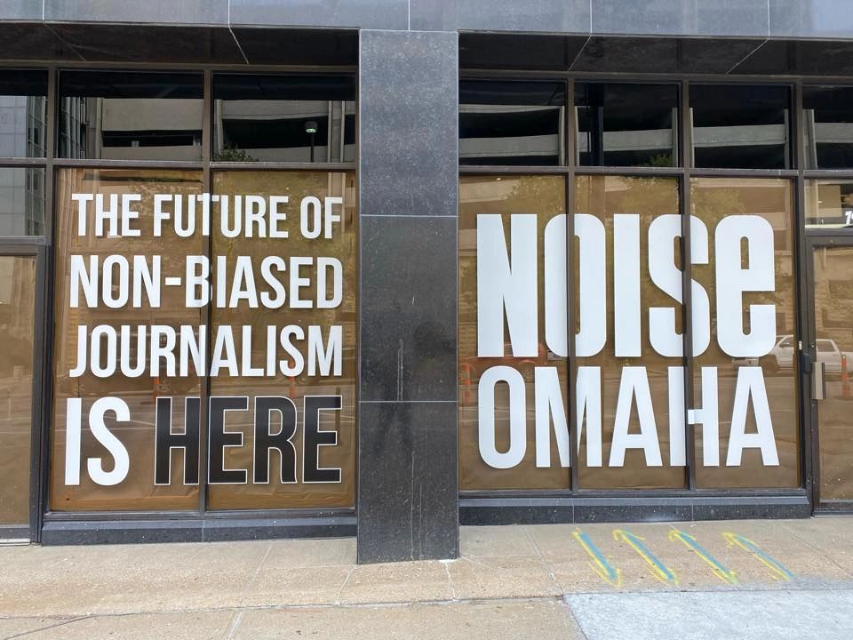 Sign outside storefront saying The Future of Non-Biased Journalism is Here: NOISE Omaha