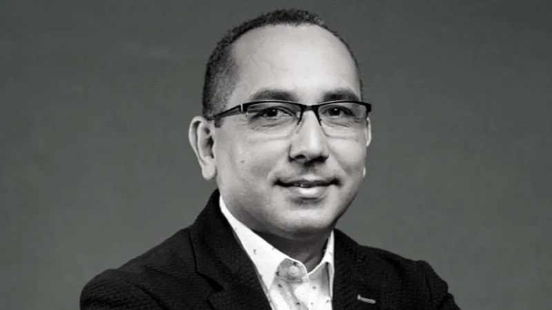 Latino man in collared suit and jacket smiling