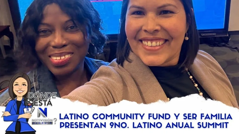 Hispanic woman and Black woman standing together in front of a screen taking a selfie and smiling