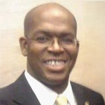 Black man in a suit and tie smiling