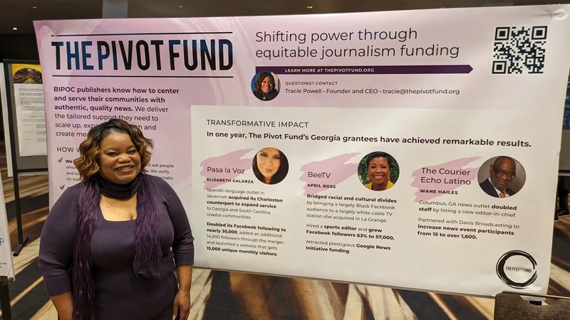 Smiling Black woman in front of a Pivot Fund presentation poster.