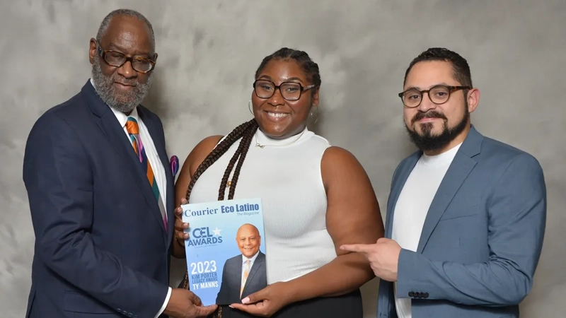 Black man, Black woman and Latino man smiling and holding an issue of The Courier Eco Latino.