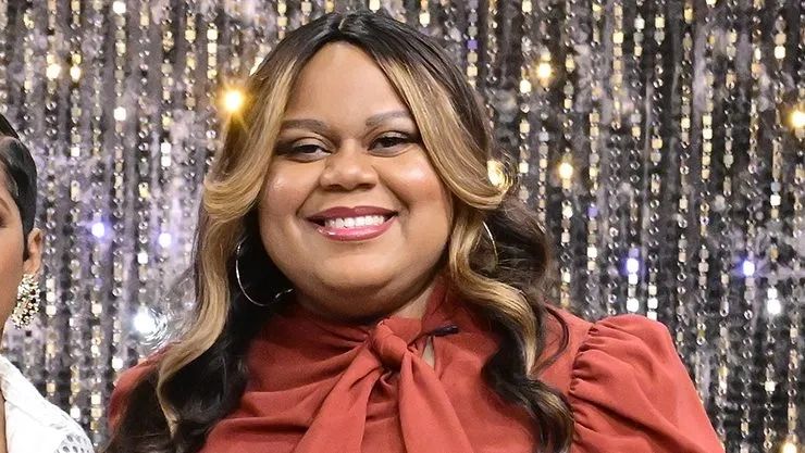Smiling woman against a sequined background