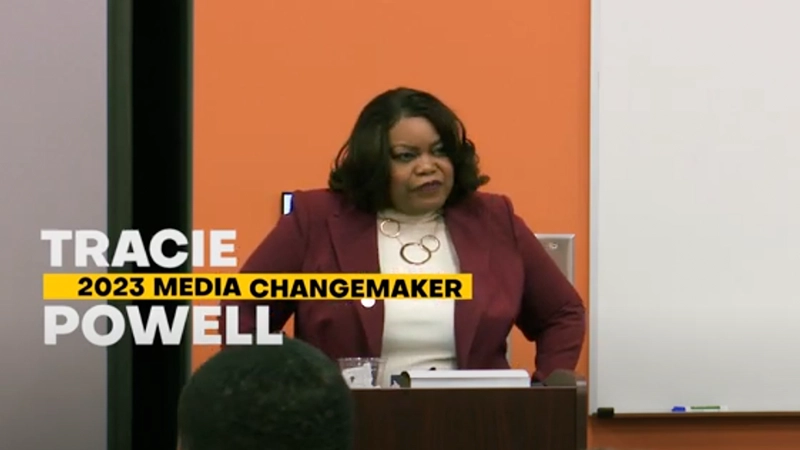 Tracie Powell at a podium speaking.