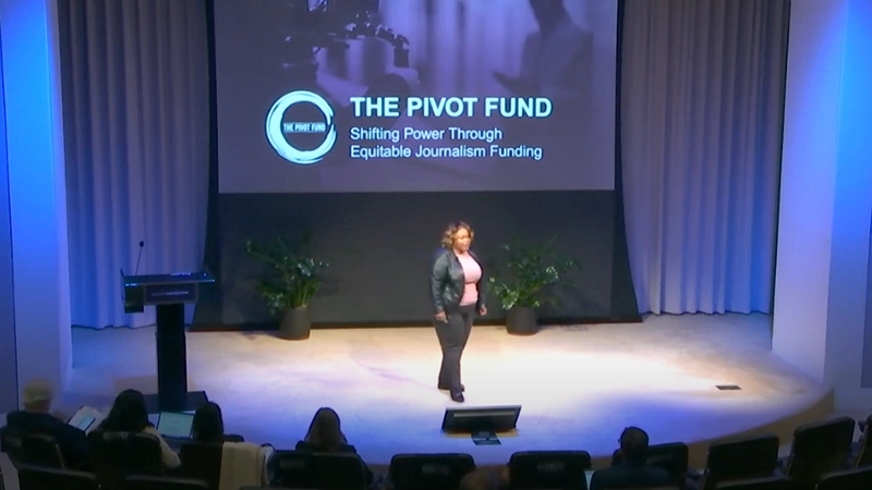 Tracie Powell presenting in front of a large screen with the Pivot Fund logo displayed