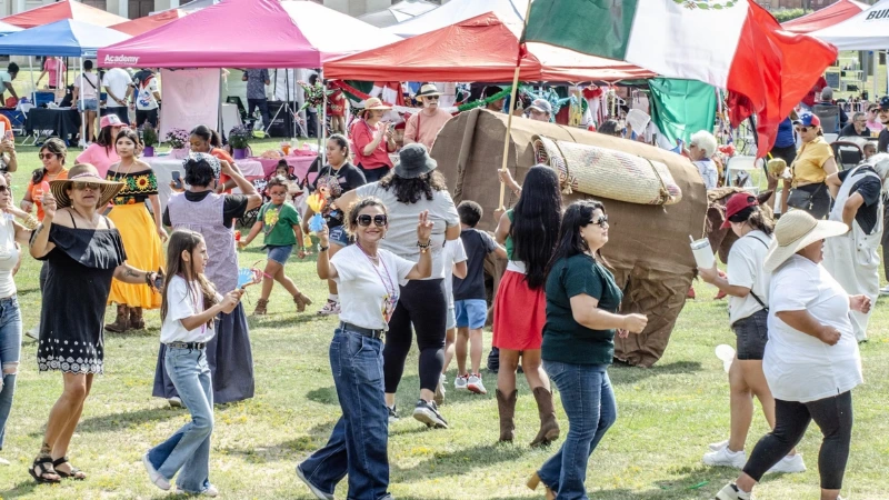 People dance in a circle outside