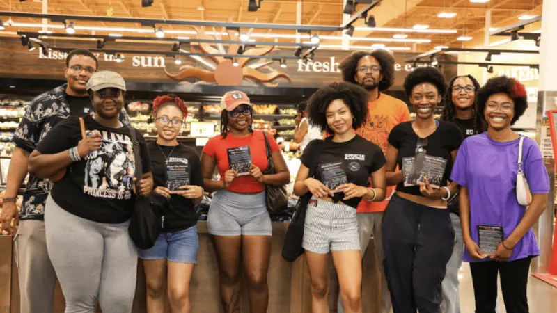 KC Defender Mutual Aid Team stands in front of produce at a local grocery store.